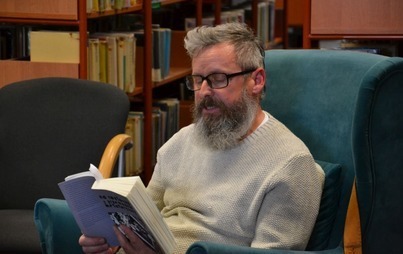 Robert Gmiterek czytający ksiażkę.